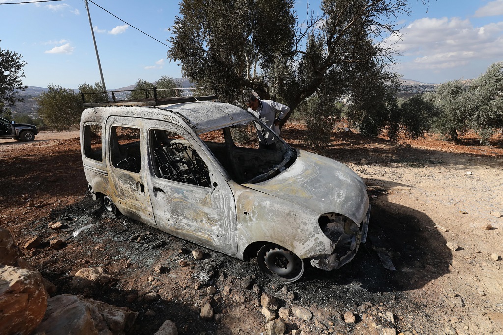 مواطن يتفقد مركبته التي أحرقها مستعمرون خلال مهاجمتهم المزارعين في قرية بيتا جنوب نابلس (تصوير: أيمن النوباني/وفا)